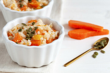 Porridge with pumpkin and pumpkin seeds on white table