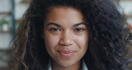 Cheerful african american woman looking at camera laughing with dental smile. Beautiful smiling young female 20 pretty face looking at camera posing alone at home, Close-up face portrait macro shot