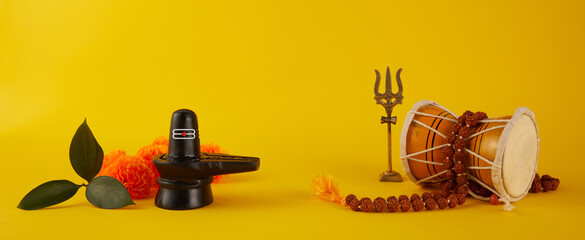 Happy Maha Shivaratri greeting card - Shiva Linga decorated with flowers, trishula, damru and bilva...