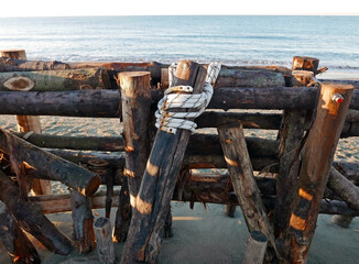 gruppo di tronchi di legno legati in spiaggia in inverno © tiziana