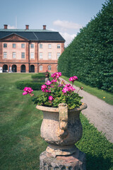 Pink flowers in antique pot in the castle gardens of &Ouml;vedskloster in Sk&aring;ne (Scania) Sweden