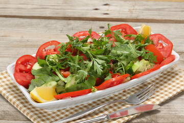 Green salad, tomatoes, cucumbers, carrot, lettuce, lemon, spice
