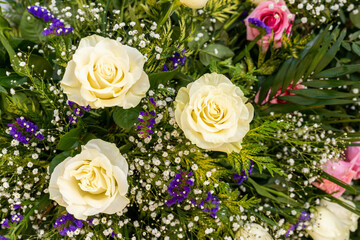 close up view of a funeral wreath with roses and other flowers