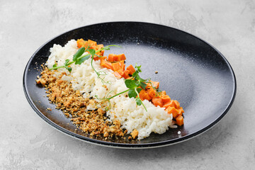 Garnish to the main dish - boiled rice, fried carrot and bread crumbs