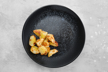 Slices of boiled potatoes fried in oil, top view
