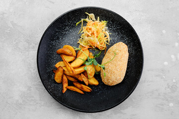 Cutlet stuffed with cheese served with potato wedges and sauerkraut