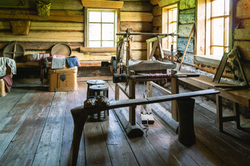 An old wooden loom in a wooden house built in the 19th century. Vintage wooden objects in the room of a wooden farmhouse