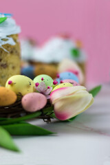 Easter card. Kulich with sugar fudge in a wreath of tulips and eggs. Marshmallow fudge with decoration.