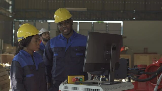 Team of Robotics engineer Look at computer about research and analysis automation robot arms machine in factory industrial for Production Line using system software support operator Industrial.
