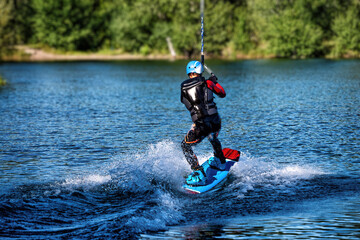 Fototapeta na wymiar Wakeboarding on the sea on summer day in life jacket. Soft focus. Action blur.