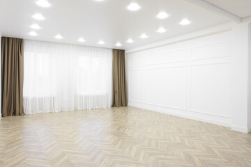 Empty room with white wall, wooden floor and spot lamps on ceiling