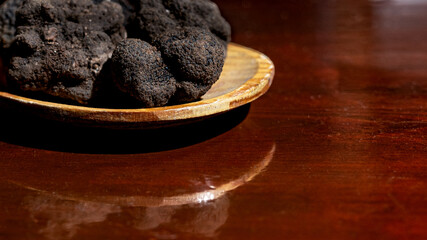 Black truffle or Périgord truffle in a wooden spoon