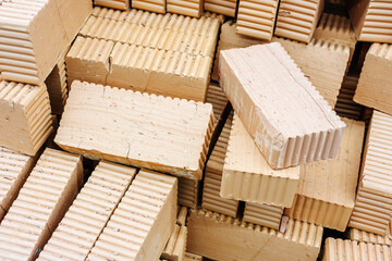 Clay bricks of a rectangular shape are located in the warehouse of a hardware store. Close-up