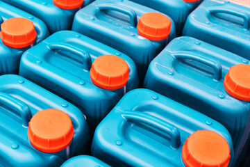 Plastic canisters with chemical liquid. Small containers with a red lid in a warehouse of an...