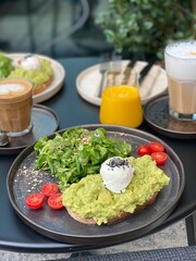 gesundes Frühstück mit Avocadobrot frühstücken und Kaffee trinken 