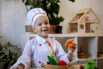 Little boy cooking from toy vegetables soup. Child's imagination. Montessori education