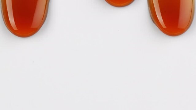 close up of flowing melted caramel sauce macro on white background