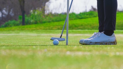 Close-up of a person putting on a golf course. golf training