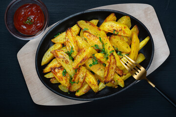 Potatoes fried in a pan, rustic style, horizontal top view