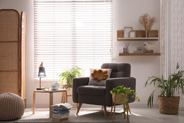 Comfortable place for rest with armchair near window in room