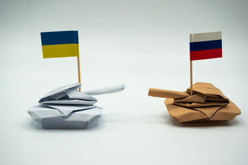 Paper folded tank with Ukrainian and Russian flags. Placed against each other.Ukraine crisis and...