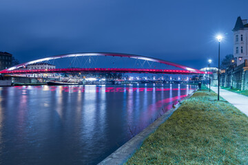 Krakow, Poland December 17, 2021; Bridge over the Vistula River in Krakow for pedestrians and cyclists. The Bernatka footbridge in the evening time.