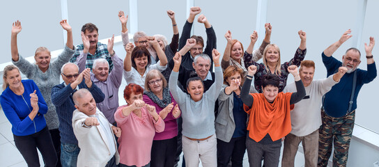 group of mature friends raised their hands up and celebrate succ