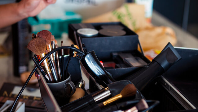 Dedicated focus Make-up converter on makeup artist's table with lots of makeup artist tools. The stack surrounds the makeup artist's table, leaving room for text.