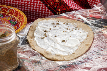 Homemade arabian flatbread (other names is pita, lavash, lafa, parantha, roti, chapati) with zaatar and labneh - 486895425