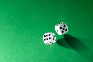 Dice, shot from above, on a green background with copy space.