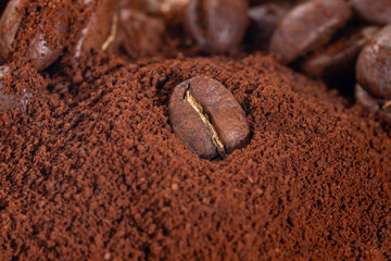 Coffee beans on ground coffee background