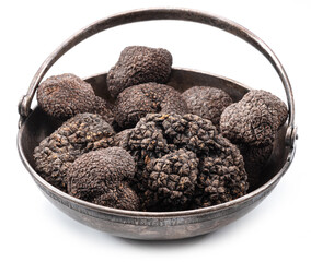 Black winter truffles in the old-fashioned tin bowl isolated on white background.