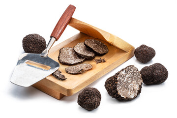 Fototapeta premium Slicing of black winter truffles isolated on white background.