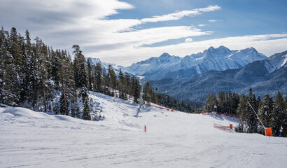 Beautiful landscape of the Arkhyz ski resort with mountains, snow, forest, skiers and snowboarders ...