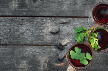 St. Patrick's Day. Clover, glass of wine on a wooden background
