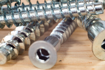 Construction abstraction. Industrial education. Hardware, screws, nails, for metal, for wood, for drywall. Bits, P2, P1, PZ2, PZ1. The screw is screwed into a wooden block. Screw confirmation.