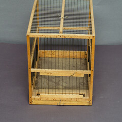 Old wooden birdcage on gray background. Handmade empty cage.