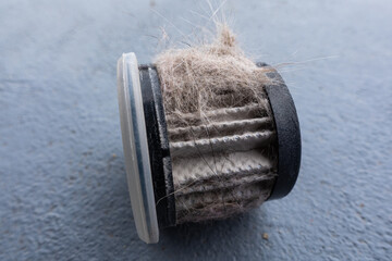 Household handheld vacuum cleaner filter clogging up with dust, mite, hair, and animal fur after an...