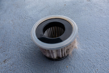 Household handheld vacuum cleaner filter clogging up with dust, mite, hair, and animal fur after an extensive household cleaning : allergy, unhygienic concept