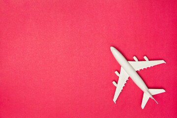 Airplane model. White plane on pink background. Travel vacation concept. Summer background. Flat lay.