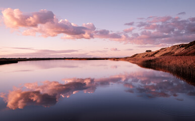 Fototapeta na wymiar Nymindegab Steg mit wolken die sich im See spiegeln Dänemark