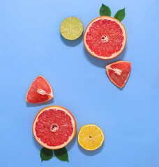 Creative exotic copy space background with citrus grapedruits, lemon and lime with green leaves. Flat lay minimal.