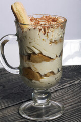 Dessert with Savoiardi cookies and cream. Tiramisu cookies. Close-up.