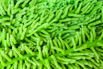 Long green pile fabric. Fabric bristles of a green brush for mopping, close-up.