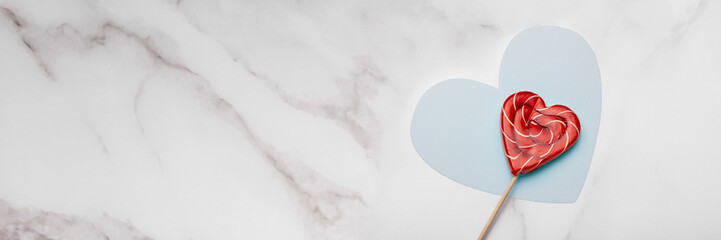Heart shaped lollipops on white marble background. Candy Love concept. Valentine's Day. Banner.