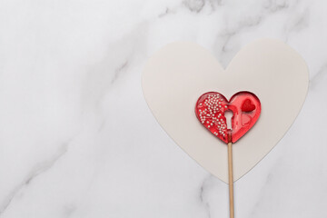 Heart shaped lollipops on white marble background. Candy Love concept. Valentine's Day.