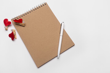 Blank notebook with white pen on white isolated desk background. Isolated on white backdrop.