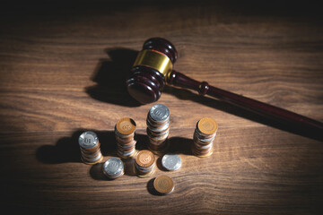 Coins with a wooden judge gavel.
