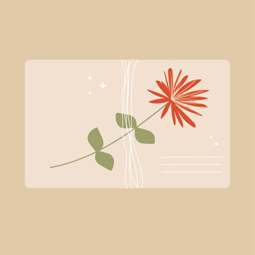 An envelope tied with a thread of kraft paper with a wildflower.