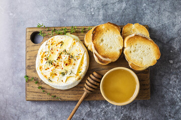 Baked camembert with toasts, honey and thyme. Top view